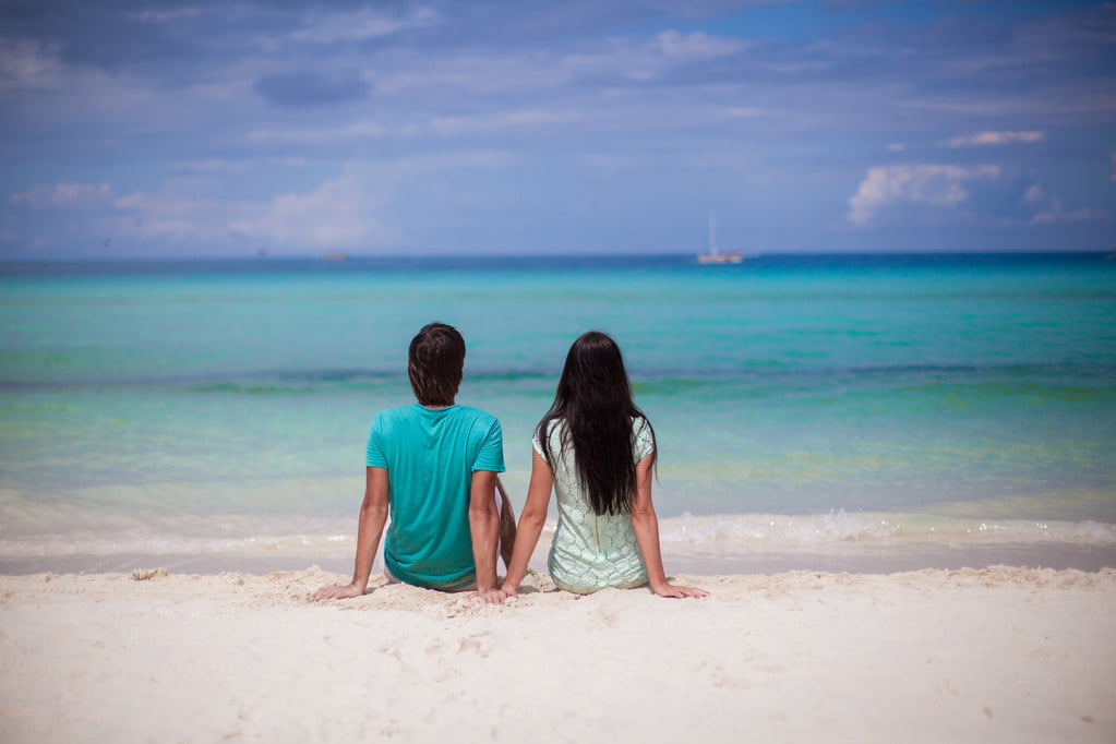 Young couple enjoying each other on sandy white beach